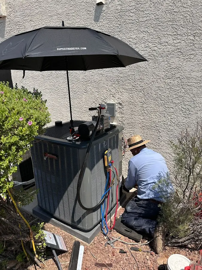 HVAC technician performing outdoor AC maintenance in Oronoko